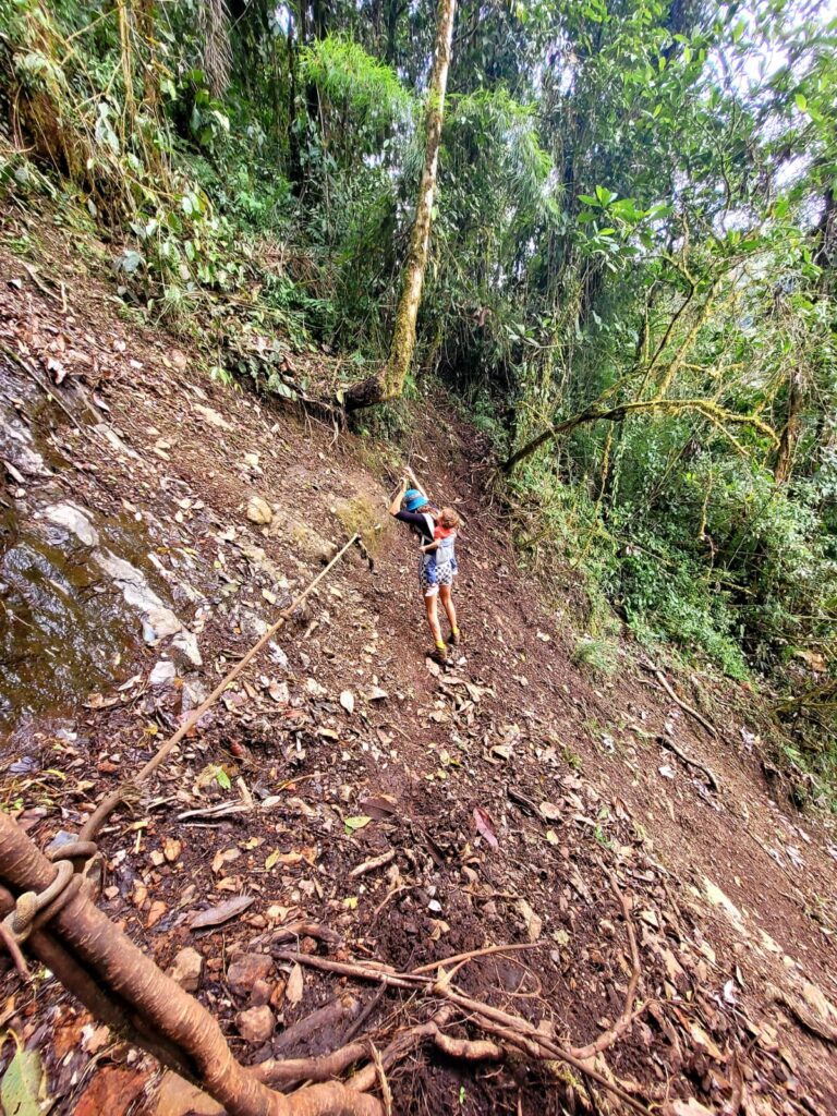 A women crossing over a steep slop using a rope 