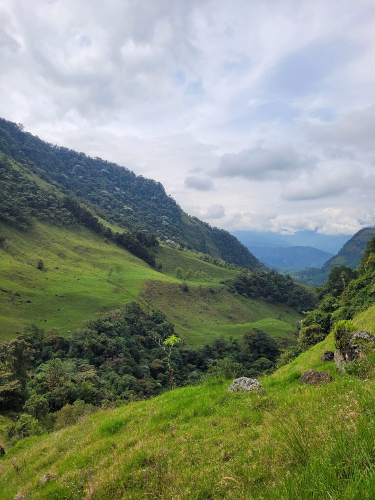 Steep green slops and a view to a valley 